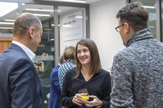 Dwóch mężczyzn i kobieta dyskutujący podczas przerwy kawowej,