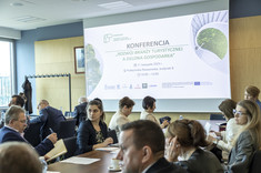 Na zdjęciu uczestnicy konferencji w tle na ścianie slajd z tytułem konferencji,