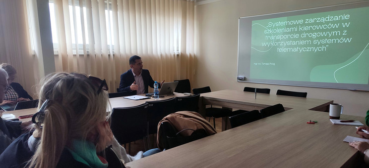 Na zdjęciu po lewej stronie dr inż. T. Piróg, na ścianie frontowej wyświetlony slajd z tytułem dysertacji, fot. organizatorzy