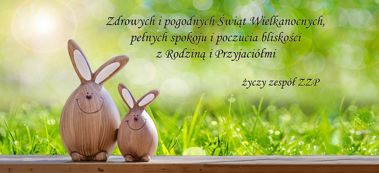 Grafika przedstawia dwa drewniane króliczki na tle trawy, nad nimi tekst życzeń (treść dostępna pod grafiką w formie tekstowej),