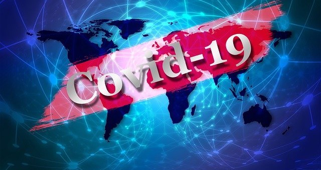 Na grafice napis Covid-19 na tle mapy świata,