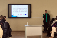 Na zdjęciu dr A. Migała-Warchoł podczas prowadzenia zajęć dla studentów. W kadrze po lewej ekran z prezentacją, po prawej dr A. Migała-Warchoł, 